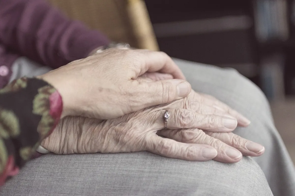 Two people holding hands in comfort