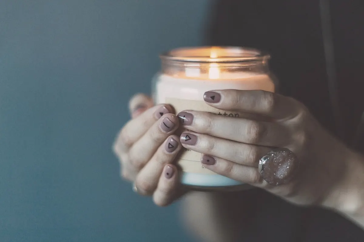 Hands holding a lit candle